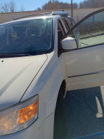 Front view of a 2010 Dodge Grand Caravan SXT with open door, ideal for family or cargo use.