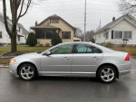 2009 Volvo S80 T6 AWD parked in a residential area, showcasing its sleek design and silver color.