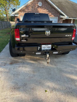 Rear view of a black 2018 Ram 3500 Big Horn dually truck with heavy-duty bumpers and tow hitch