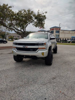 2016 Chevrolet Silverado 1500 LT 4WD in a parking lot, showcasing its rugged design and clean exterior.