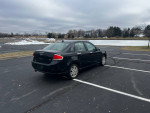 2010 Ford Focus SES in black parked in a scenic lot, showcasing its sleek design and excellent condition.