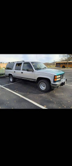 1994 GMC Suburban in silver, running great, dependable with new parts, ideal for snowy conditions.
