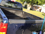 View of the bed of a 2000 Chevy Silverado LS, featuring a clean interior and fishing gear.