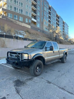 2005 Ford F-350 King Ranch 4x4 truck in good condition, parked near an apartment complex. Salvage title.