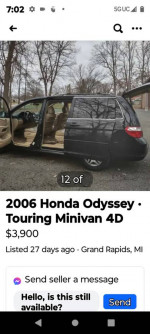 2006 Honda Odyssey Touring minivan with open doors, showing leather interior, parked in Grand Rapids, MI.