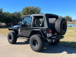 2006 Jeep Wrangler with 4-inch lift and aftermarket fenders parked outdoors.