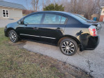 2011 Nissan Sentra sedan in black with stylish rims and clean condition parked on grassy area