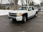 2011 Chevrolet Silverado 1500 LTZ 4WD in white, parked in residential area, showcasing its clean design and good condition.