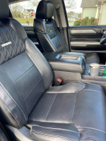Interior view of 2014 Toyota Tundra Platinum with black leather seats and modern accessories.