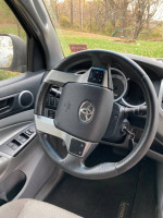 Interior view of a 2013 Toyota Tacoma PreRunner with a clean steering wheel and dashboard.