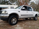 White Ford F-150 truck for sale, features new stereo, backup camera, and 4-wheel drive functionality.
