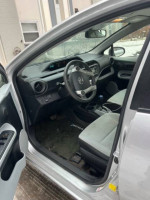 Interior view of a 2014 Toyota Prius C showing dashboard, steering wheel, and seats.