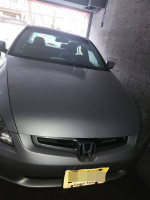 Damaged 2005 Honda Accord with clean title, showing front view in garage.