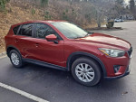 2013 Mazda CX-5 in good condition with new tires and minor cosmetic scuffs parked in a scenic area.