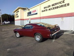1970 Ford Mustang Mach 1 in Royal Maroon parked outside a golf cart dealership