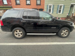 2005 Ford Explorer XLT 4WD parked on the street in Brooklyn, showcasing its black exterior and new inspection sticker.