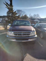 Front view of a Ford F250 truck with a long bed, showing a clean body but requiring engine repairs.