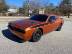2011 Dodge Challenger in bright orange with black accents, showcasing muscle car features and great condition.