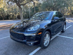 2015 Porsche Cayenne S AWD parked in a sunny area with trees, showcasing its sleek design and great condition.