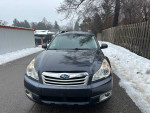 Front view of a 2011 Subaru Outback, a reliable AWD vehicle with low mileage, parked on a snowy road.