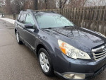 2011 Subaru Outback in gray parked on a driveway, showcasing its reliable and well-maintained exterior.