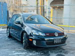 2013 Volkswagen GTI Driver's Edition in black, showcasing alloy wheels and sporty design, parked on snowy ground.