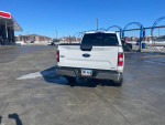 2018 Ford F-150 XLT 4WD parked at a gas station, showcasing its rear and clean exterior.