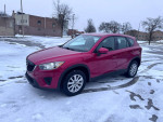 2014 Mazda CX-5 Sport in red parked on snow-covered ground, showcasing alloy wheels and modern design.