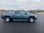 2011 Chevrolet Silverado 1500 LT 4WD in blue parked by the water, showcasing its clean exterior and modern design.