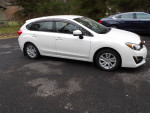 2015 Subaru Impreza with pearl white metallic paint parked on a driveway, featuring premium wheels and AWD.