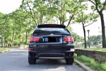 Rear view of a 2013 BMW X5 xDrive35i, showing its sleek design and luxury features in a natural setting.