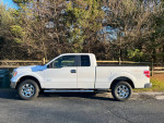 Side view of a well-maintained Ford F150 4x4 EcoBoost truck with 80,000 miles parked outdoors.