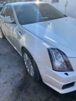 White Cadillac CTS performance sedan with minor front bumper damage and clean exterior
