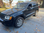 2008 Jeep Grand Cherokee Limited in black, featuring leather seats and sunroof, parked in a residential area.