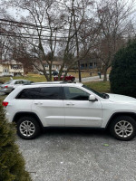 2015 Jeep Grand Cherokee Laredo with 106,000 miles, showing exterior in excellent condition, parked on gravel.