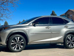 2018 Lexus NX 300 FWD shown in a residential driveway with a clear sky, highlighting its sleek design and alloy wheels.