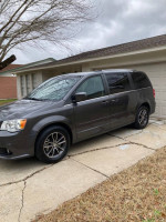 2017 Dodge Grand Caravan parked in driveway, spacious family van with dual sliding doors and reliability.
