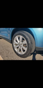 Close-up of a wheel and tire on a 2013 Mitsubishi Outlander SUV for sale.