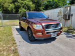 2010 Ford Explorer XLT RWD in clean condition, parked on a driveway with green surroundings.