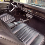 Interior view of a 1968 Beaumont showcasing classic black leather seats and dashboard features.