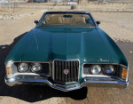 Front view of a green 1972 Mercury Cougar XR7 Convertible with new seats and a light tan top.