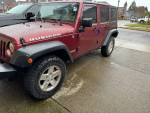 2008 Jeep Wrangler Rubicon 4WD in dark red with clean body and 20-inch black rims parked on concrete