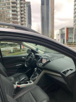 Interior view of a 2013 Ford Escape SEL in Sterling Gray, featuring leather seats and modern dashboard design.