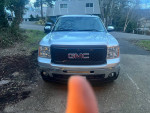 Front view of a 2012 GMC Sierra 1500 SLT 4WD truck parked in a residential area