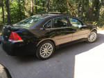 2007 Black Chevrolet Impala SS with 109,000 miles, fully loaded, parked in a forested area.