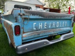 1965 Chevrolet truck with vintage patina and relocated fuel tank, viewed from the rear