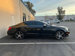 Side view of a 2012 Mercedes-Benz CLS550 in black, showcasing sleek design and alloy wheels, parked in a lot.