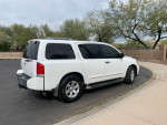 2004 Nissan Armada LE 4WD in white, parked with trees in the background, showcasing its sporty design and new tires.