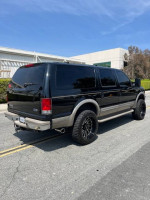 2001 Ford Excursion Limited 7.3 Diesel in black with a 6 inch lift, parked on the street.