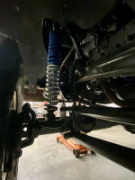 Close-up of the suspension system showing Fox coilovers on a 1990 Dodge Ramcharger 4x4 during restoration.